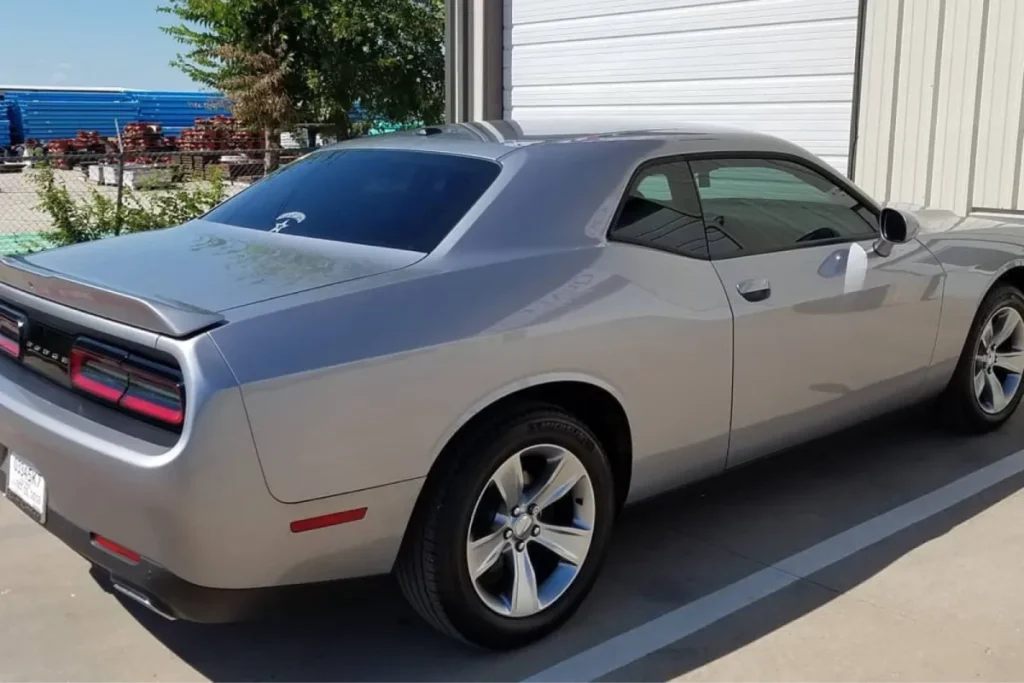 Side rear view of silver Dodge Challenger parked outdoors.